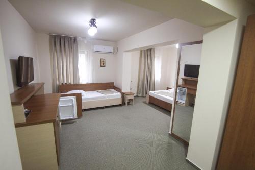 a hotel room with a bed and a mirror at Teju Hotels in Slănic