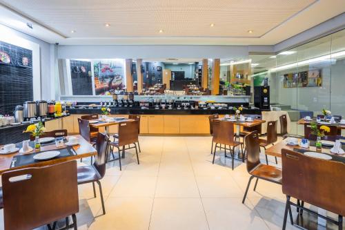 a restaurant with tables and chairs and a bar at ibis Styles Belém do Pará in Belém
