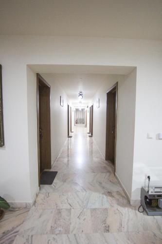 an empty hallway with white walls and marble floors at Teju Hotels in Slănic