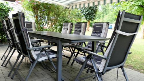 a group of chairs around a black table at Helles Ferienhaus im Landhausstil für bis zu 10 Personen in Frielendorf