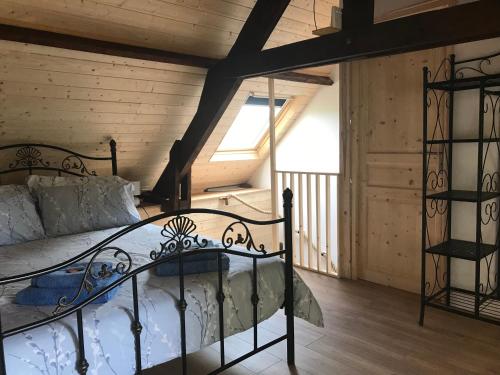 - une chambre mansardée avec un lit en métal dans l'établissement Ferme de Noyes Cottage, à Sourdeval