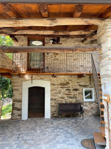 a stone building with a bench and a balcony at La Fnera in Cavaliggi