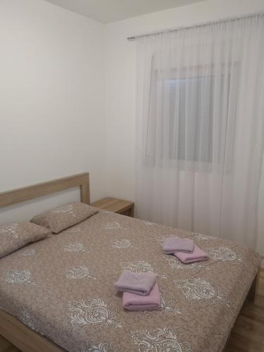 a bedroom with a bed with two towels on it at Jednosoban stan Zoja in Podgorica