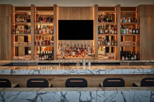 a bar in a hotel with a large marble counter at Pendry Park City in Park City