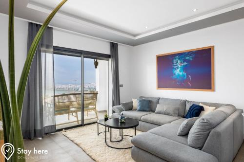 uma sala de estar com um sofá e uma mesa em Stayhere Agadir - Ocean View Residence em Agadir