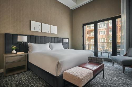 a bedroom with a large white bed and a chair at Pendry Park City in Park City