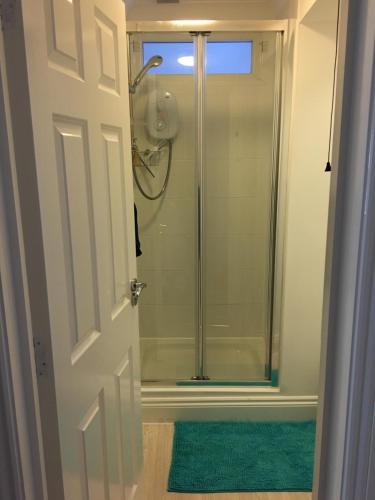 a bathroom with a shower and a green rug at Quirky 1 bedroom Apartment in Boscombe in Bournemouth