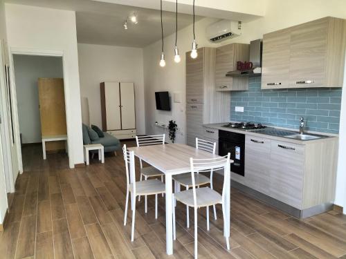 a kitchen and dining room with a table and chairs at Appartamenti MiNuMa Tropea in Tropea