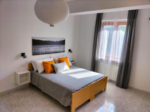a bedroom with a large bed with orange pillows at Appartamenti MiNuMa Tropea in Tropea