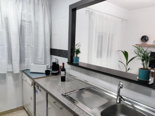 a kitchen counter with a sink and a mirror at La Brisa apartamento in Málaga