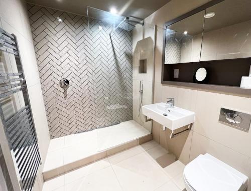 La salle de bains est pourvue d'une douche, d'un lavabo et de toilettes. dans l'établissement The Aviator's Attic - Luxury City Centre Retreat, à York
