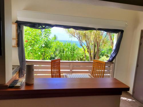 a table and chairs on a balcony with a view at Villa Dream in Deshaies