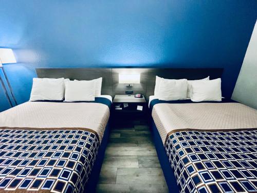 Tempat tidur dalam kamar di Americas Choice Inn & Suites
