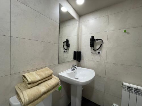 Baño blanco con lavabo y espejo en APARTAMENTOS RioMonte 2 - DeLuxe en Boltaña