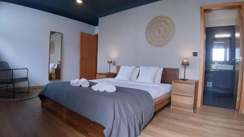 een slaapkamer met een groot bed en handdoeken bij Amateur Runners in Água de Alto