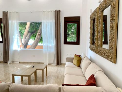 a living room with a white couch and a table at AMPLIA VIVIENDA NEW para12 pers a 4 min caminando de PLAYA con Terraza, Piscina Com, Wifi, Ventiladores de techo, Lavavajillas in Roquetas de Mar