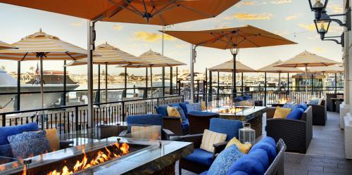 a patio with chairs and tables and umbrellas at Balboa Bay Resort in Newport Beach