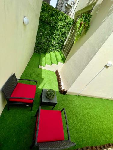 a room with green grass and two red chairs at فلامينجو Flamingo in Abha