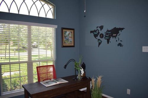 a blue room with a desk and a world map on the wall at Spacious Conroe Home around 4 miles to the Lake in Montgomery