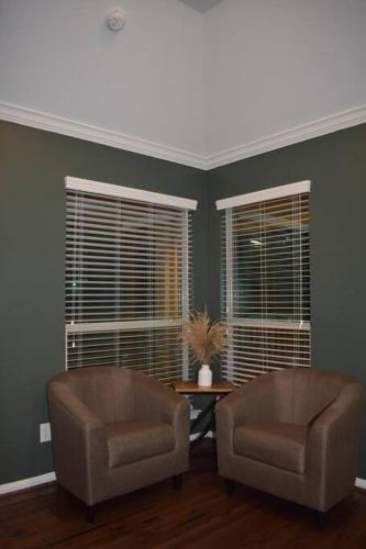 two chairs in a living room with two windows at Spacious Conroe Home around 4 miles to the Lake in Montgomery
