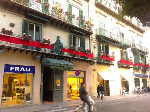 Ein Mann, der eine Straße entlang fährt, neben einem Gebäude in der Unterkunft Massimo Plaza Hotel in Palermo