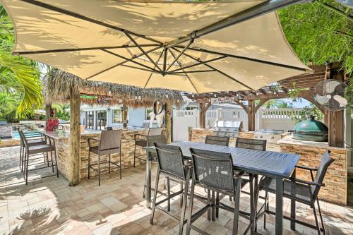 a patio with a table and chairs under a large umbrella at Luxe Cape Coral Escape with Pool 4 Mi to Beach in Cape Coral
