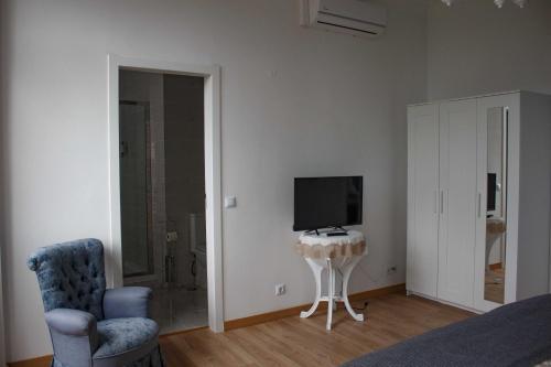 a living room with a tv and a chair and a bed at Flor&Fidalgo Guest House in Sintra