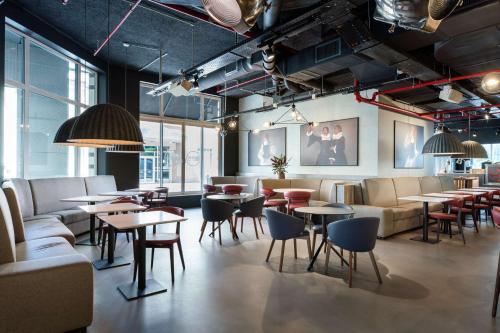 a restaurant with tables and chairs and a couch at Radisson RED Brussels in Brussels