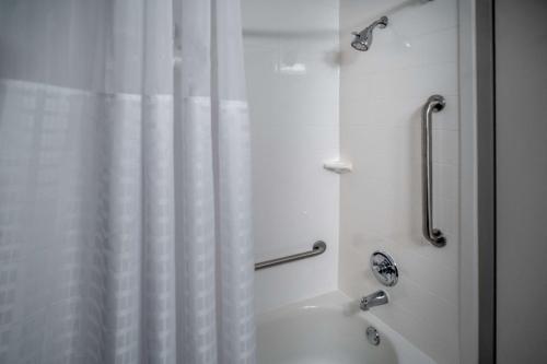 a bathroom with a shower with a white shower curtain at Best Western Plus Beckley Inn in Beckley