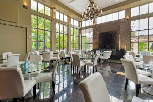 un comedor con mesas, sillas y ventanas en Best Western Plus Perth Parkside Inn & Spa, en Perth