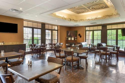 ein Restaurant mit Holztischen und -stühlen und Fenstern in der Unterkunft Perth Parkside Hotel and Spa, BW Premier Collection in Perth