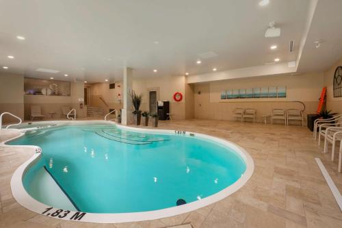 una gran piscina en una gran habitación con mesas y sillas en Best Western Plus Perth Parkside Inn & Spa, en Perth