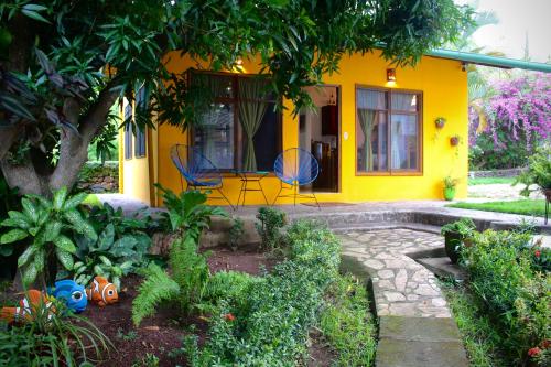 a yellow house with two chairs in front of it at Casa Única in La Laguna