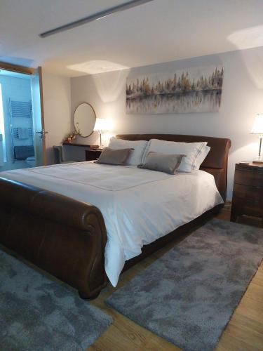 a bedroom with a large bed with white sheets and pillows at Mulranny Bay Apartment in Mulranny