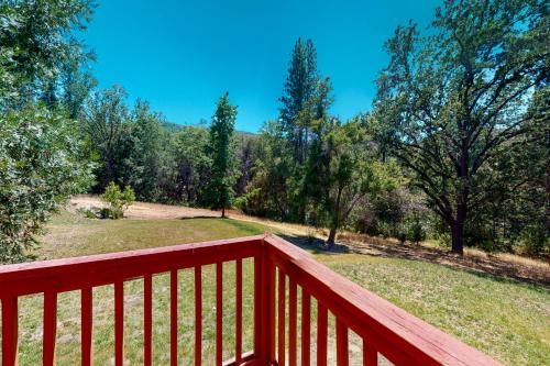 a wooden deck with a view of a field and trees at Yosemite Nutter Ranch in Mariposa