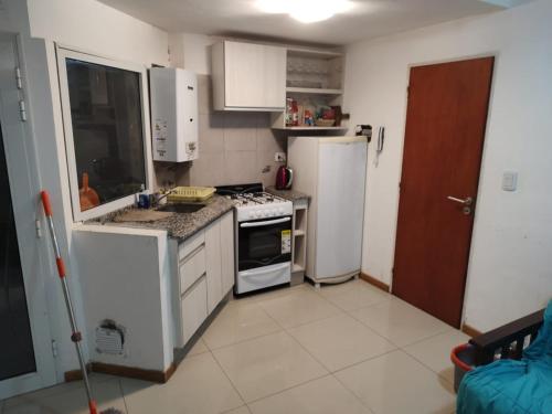 a kitchen with a refrigerator and a stove top oven at Departamento completo in Rosario