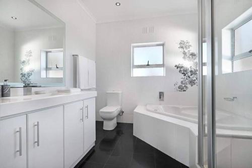Baño blanco con aseo y lavamanos en Prestigious Guest Villa, en Ciudad del Cabo