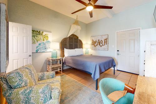 a bedroom with a bed and a couch and a fan at Beachview 321 in Gulf Shores