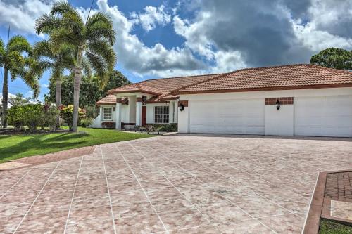 a house with a driveway and palm trees at Pet-Friendly Port St Lucie Home - 7 Mi to Beaches! in North River Shores
