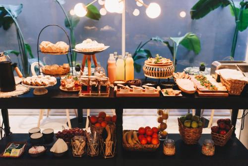 a table with food and drinks and baskets of food at LG Golden Suites in San Miguel de Tucumán