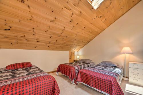 two beds in a room with a wooden ceiling at Mountain-View Campton Retreat about 3 Mi to Ski Slopes in Campton