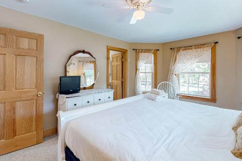 a bedroom with a large white bed and a television at The Wheelhouse in Camden
