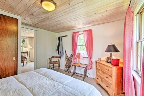 a bedroom with a bed and a desk and a window at Charming Horicon Cottage and Dock on Rock River in Juneau