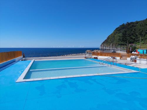 a swimming pool with the ocean in the background at Casa do sanguinho in Faial da Terra