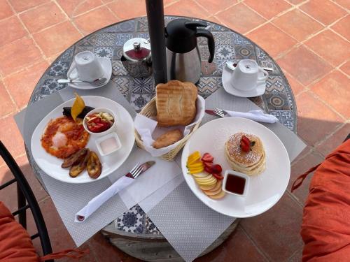 een tafel met twee borden ontbijtproducten erop bij Nico Hotel in Antigua Guatemala