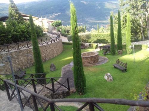 un parque con árboles y una pared de piedra y bancos en Tenuta il Giardino di Eros, en Albanella