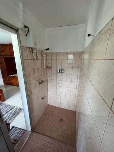 a bathroom with a shower with a tiled floor at Hill Bottom Accommodation in Suva
