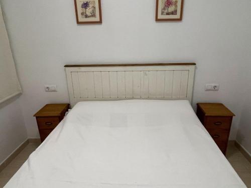 ein Schlafzimmer mit einem weißen Bett und zwei Nachttischen in der Unterkunft Charming apartment in Denia with terrace in Denia