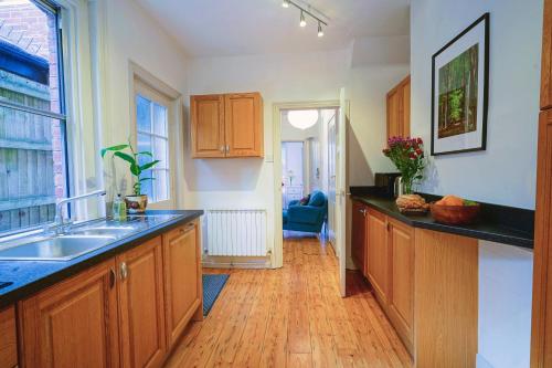 a kitchen with wooden cabinets and a sink at Cosy 1-Bed Escape with Free Parking - At Hem in Winchester