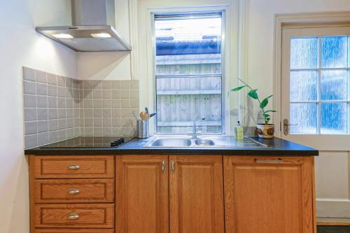 a kitchen with a sink and a window at Cosy 1-Bed Escape with Free Parking - At Hem in Winchester